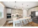 Modern kitchen features white cabinets, stainless steel appliances, a large center island, and pendant lighting at 9858 Quercus Ln, Huntersville, NC 28078