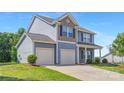 Light blue home featuring a two-car garage, well-manicured lawn, and classic architectural details at 129 Canada Dr # 85, Statesville, NC 28166