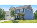 Attractive home with light blue siding, a two-car garage, and a well-maintained front yard with mature trees at 129 Canada Dr # 85, Statesville, NC 28166