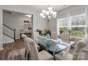 Bright dining room featuring a glass table, chandelier, and large windows, perfect for Gathering gatherings and entertaining at 15021 Meacham Farm Dr, Huntersville, NC 28078