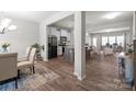 Open-concept living space with hardwood floors, neutral tones, seamless transition to the kitchen and dining areas, and lots of light at 15021 Meacham Farm Dr, Huntersville, NC 28078