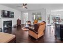 Inviting living room with a fireplace, dark hardwood flooring, and abundant natural light from a nearby window at 15429 Topanga Dr, Charlotte, NC 28278