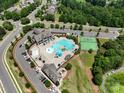 Aerial view of the community pool and clubhouse, surrounded by lush landscaping and parking at 15429 Topanga Dr, Charlotte, NC 28278