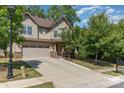 A two-story home with a two-car garage, landscaped front yard, and a long concrete driveway in a suburban neighborhood at 15536 Oleander Dr # L228, Charlotte, NC 28278
