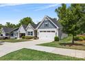 A charming home showcasing a two-car garage, manicured lawn, and stylish architectural details under a bright blue sky at 1747 Slippery Rock Ln, Monroe, NC 28112