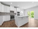Bright kitchen features white cabinets, stainless steel appliances, a kitchen island, and a view to the outside at 1747 Slippery Rock Ln, Monroe, NC 28112