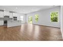 Bright living room featuring hardwood floors, large windows, and modern finishes at 1747 Slippery Rock Ln, Monroe, NC 28112