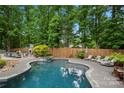 Inviting backyard pool with a spa, lounge chairs, and a covered outdoor kitchen, perfect for entertaining at 19507 Dufour Ct, Cornelius, NC 28031