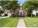 Beautiful brick home with manicured lawn, mature trees, and attached two car garage at 20107 N Cove Rd, Cornelius, NC 28031