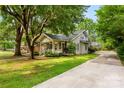 Home surrounded by mature trees, featuring a well-manicured lawn and long driveway at 204 S Elm St, Cherryville, NC 28021
