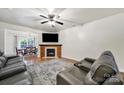 Bright living room with a fireplace, ceiling fan, wood floors, and comfortable seating at 2117 Seabrook Ln, Fort Mill, SC 29715