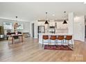Open-concept kitchen features white cabinets, stainless appliances, a large island, and an adjacent dining area at 2678 Wedgewood Ct, Denver, NC 28037