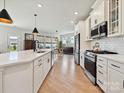 Bright kitchen featuring an island, stainless steel appliances, white cabinetry, and wood floors with an open layout at 2678 Wedgewood Ct, Denver, NC 28037