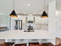 Stylish kitchen with quartz countertops, a modern faucet, a subway tile backsplash, and stainless steel appliances at 2678 Wedgewood Ct, Denver, NC 28037