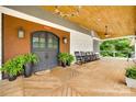 Charming covered porch with wood flooring, wood ceiling, stone accents, and rocking chairs overlooking a lush landscape at 3091 Old Meeting House Rd, Sharon, SC 29742