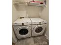 Well-lit laundry area with a side-by-side washer and dryer, complemented by overhead shelving for storage at 324 Gaines Rd # 8, Clover, SC 29710