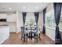 Cozy dining area featuring a glass-top table with gray chairs, natural lighting, and blue curtains at 4015 Havenport Cir, Fort Mill, SC 29708