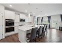 Modern kitchen with a large island, stainless steel appliances, white cabinets, and a dining area with blue curtains at 4015 Havenport Cir, Fort Mill, SC 29708