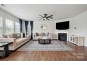 Bright living room with hardwood floors, two couches, a fireplace, and natural light streaming through large windows at 4015 Havenport Cir, Fort Mill, SC 29708