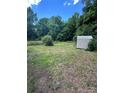 A spacious backyard featuring trees and a storage shed at 407 Lincoln St, Wadesboro, NC 28170