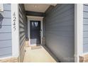 Inviting front entrance showcasing a stylish dark grey front door, coordinating sidelights, and modern house numbers at 4245 Millstream Rd, Denver, NC 28037