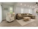 Bright living room featuring hardwood floors and neutral walls, complemented by a sectional and recessed lighting at 443 Brandon St, Davidson, NC 28036
