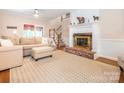 Cozy living room featuring a fireplace, plush seating, and hardwood floors at 5417 Bedfordshire Ave, Harrisburg, NC 28075