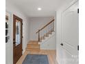 Inviting foyer with hardwood floors, white trim, and a staircase leading to the upper level at 5910 Grosner Pl, Charlotte, NC 28211