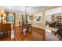 Dining room with hardwood floors and glass table, open to the living area at 611 Tee Ridge Ct, Fort Mill, SC 29715