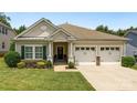 Inviting single-story home showcasing a well-maintained lawn and an attached two-car garage at 611 Tee Ridge Ct, Fort Mill, SC 29715