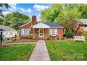 Quaint red brick home with green shutters, a chimney, a sidewalk and manicured lawn and plantings at 625 N Center St # 4, Statesville, NC 28677