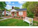 Charming red brick home with a chimney, shutters, manicured landscaping and a garden bench at 625 N Center St # 4, Statesville, NC 28677