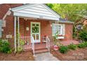 Welcoming front porch with a wreath on the mint-green door, shutters, flower boxes and alarm sign at 625 N Center St # 4, Statesville, NC 28677