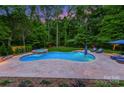 Aerial view of a backyard featuring a swimming pool, hot tub, patio area, and surrounding greenery at 7812 Seton House Ln, Charlotte, NC 28277