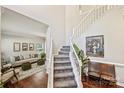 Elegant entryway with staircase, hardwood floors, and views into the living room at 7833 Taymouth Ln, Charlotte, NC 28269