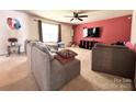 Spacious living room with carpet, large window for natural light, and TV at 815 Fescue Ct, Charlotte, NC 28216