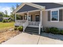 Welcoming front porch with white railings, a gray door, and well-manicured landscaping leading to the entrance at 975 Mt Moriah Church Rd, China Grove, NC 28023