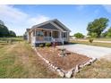 Charming single-story home featuring a cozy front porch and well-maintained yard with a decorative rock border and concrete driveway at 975 Mt Moriah Church Rd, China Grove, NC 28023