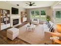 Bright and airy living room with fireplace, ceiling fan, and large windows overlooking the backyard at 10406 Baskerville Ave, Charlotte, NC 28269