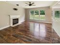 Spacious living room featuring hardwood floors, a fireplace, and large windows, providing plenty of natural light at 10406 Baskerville Ave, Charlotte, NC 28269