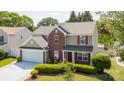 Inviting two-story home featuring a two-car garage, manicured lawn, and traditional architectural details at 10815 Mountain Springs Dr, Charlotte, NC 28278