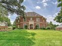 Beautiful brick home with lush green lawn, showcasing classic architecture and mature landscaping at 11321 James Jack Ln, Charlotte, NC 28277