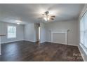 Bright living room with dark wood floors, ceiling fan, and a decorative fireplace mantel enhancing the space at 133 Pheasant Run Rd, Troutman, NC 28166