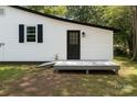 Exterior side-view of the home showing access ramp, white siding, black trim, and a well-maintained backyard at 1401 Woodman Hall St, Shelby, NC 28152