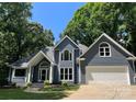 Charming two-story home featuring a front-facing garage, gray siding, and a well-manicured lawn surrounded by mature trees at 26056 Neptunes Lndg, Fort Mill, SC 29708