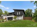 Contemporary home with a unique roofline, black siding, white brick accents, and a lush green lawn at 2913 Lake Ave, Charlotte, NC 28208