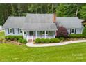 Charming home featuring a cozy front porch, lush landscaping, and a well-maintained lawn at 322 Killian Rd, Stanley, NC 28164