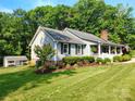 Inviting front of the house with a covered porch and manicured landscaping at 322 Killian Rd, Stanley, NC 28164