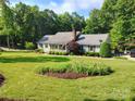 Landscaped front yard featuring a flower bed and mature trees at 322 Killian Rd, Stanley, NC 28164