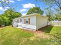 Side exterior view featuring vinyl siding, trimmed windows, and a well-maintained lawn at 411 W Sycamore St, Lincolnton, NC 28092